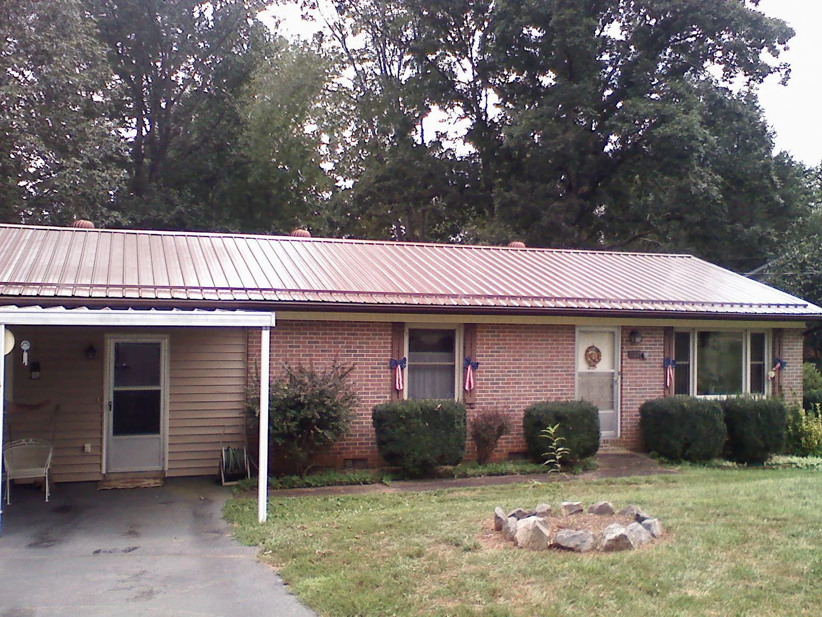 Bronze metal roof and carport on a brick ranch home — Roof Repair work by our crew in Wenham
